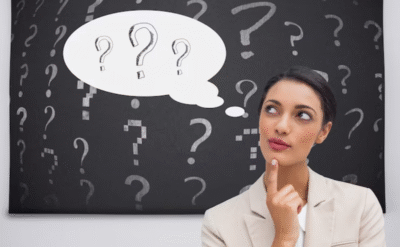A thoughtful woman surrounded by question marks, symbolizing curiosity and self-inquiry reflecting the theme of personal growth through the habit of asking questions.