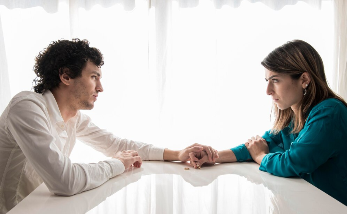 Couple facing each other during a tense moment, reflecting challenges in relationship communication.